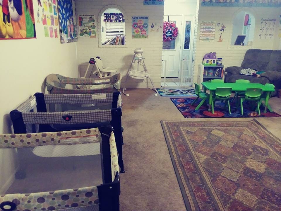 Playroom with multiple cribs and a small green table with chairs