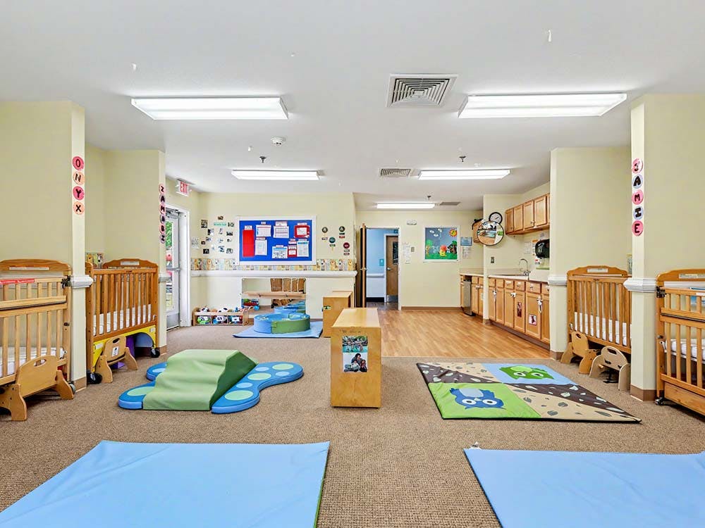 Baby room with cribs, soft play area, and kitchen counter