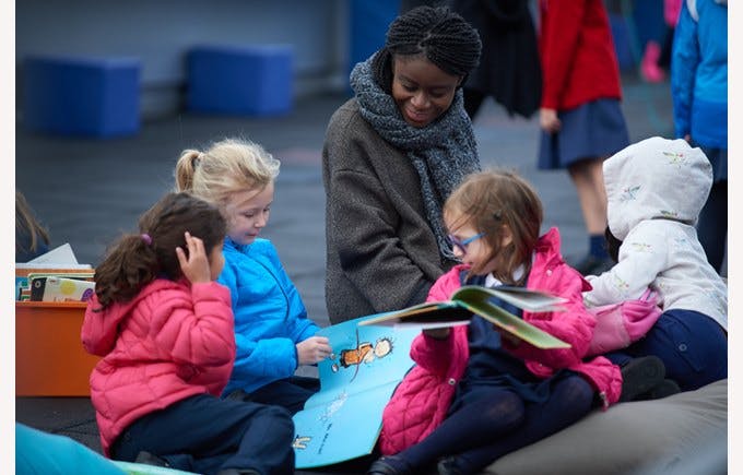 Person and children looking at books