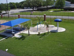 Outdoor splash pad with a blue shade canopy
