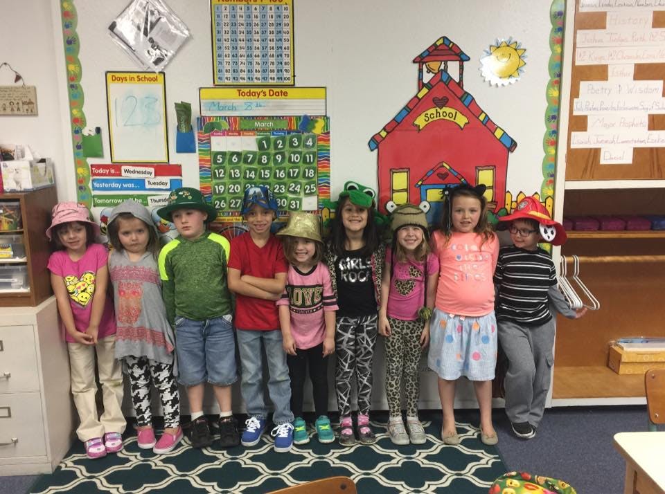 Group of children wearing hats in a classroom