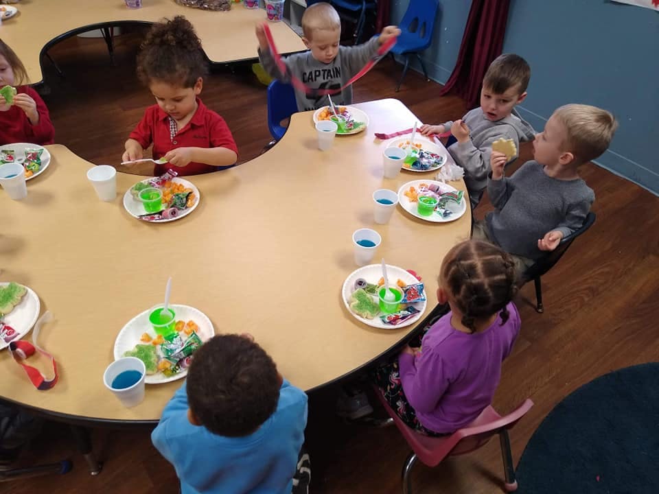Children sitting at a table with plates of food