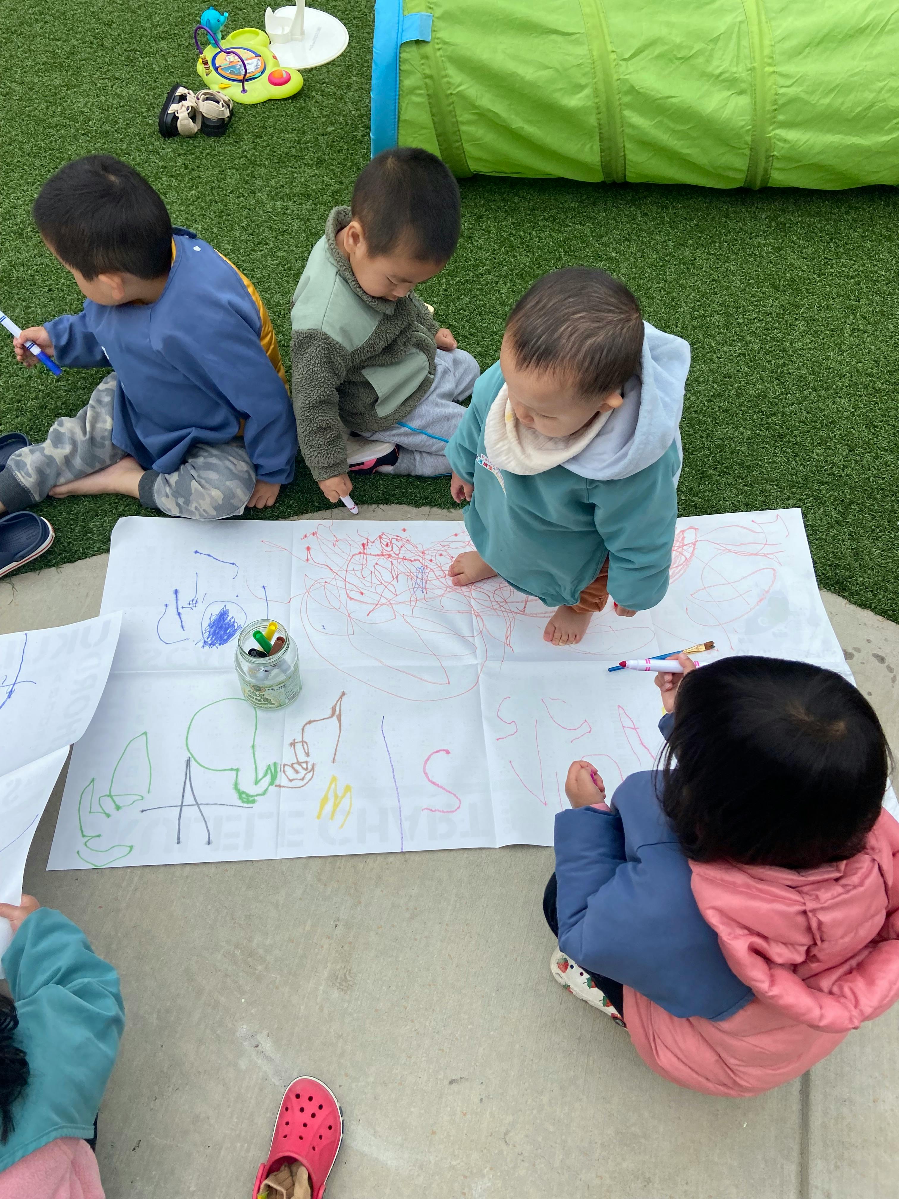 Children drawing on paper with markers