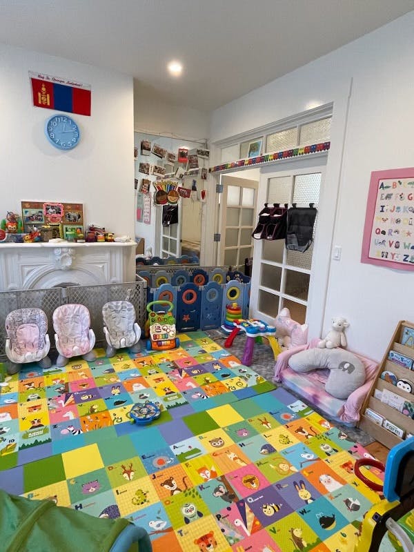 Playroom with colorful alphabet floor mats, baby seats, and toys