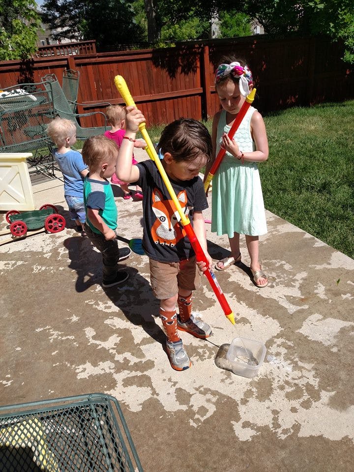 Children playing with water toys on a patio