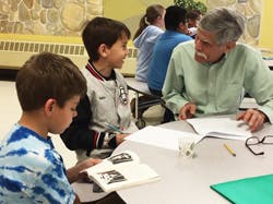 Adult and two children at a table with books