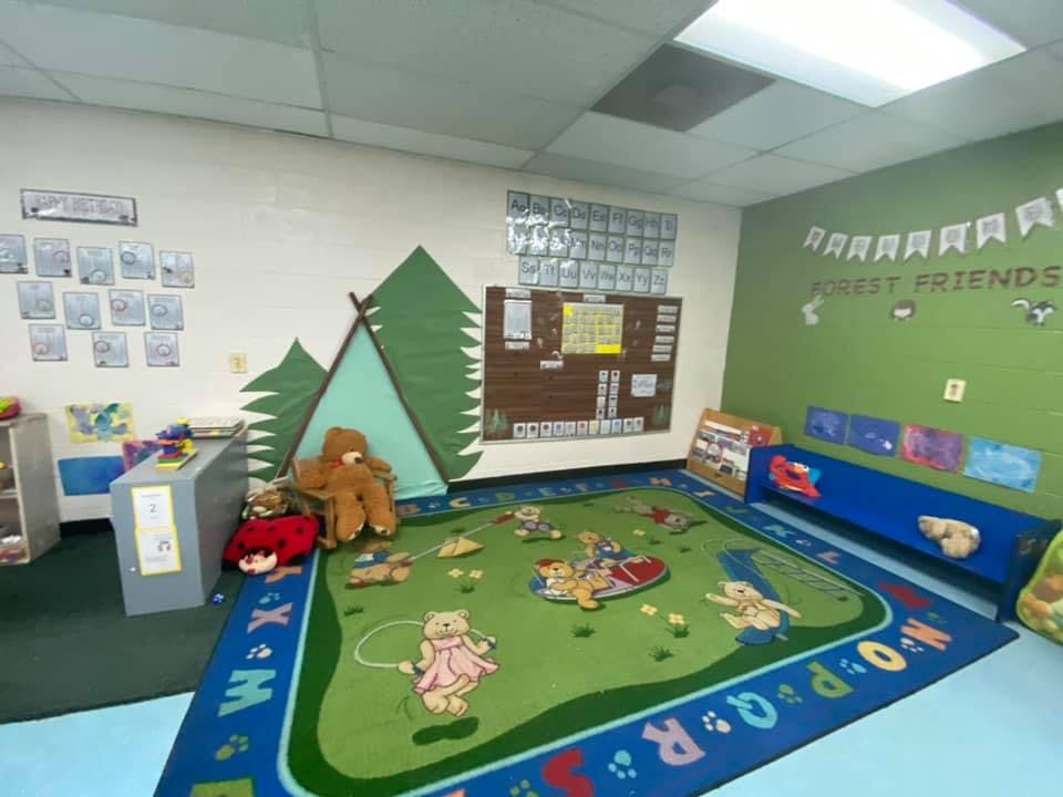 Children's play area with a rug, tent, and wall decorations