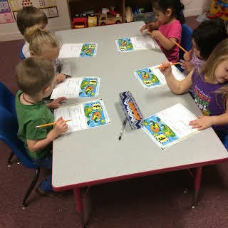 Children drawing at a table in a classroom