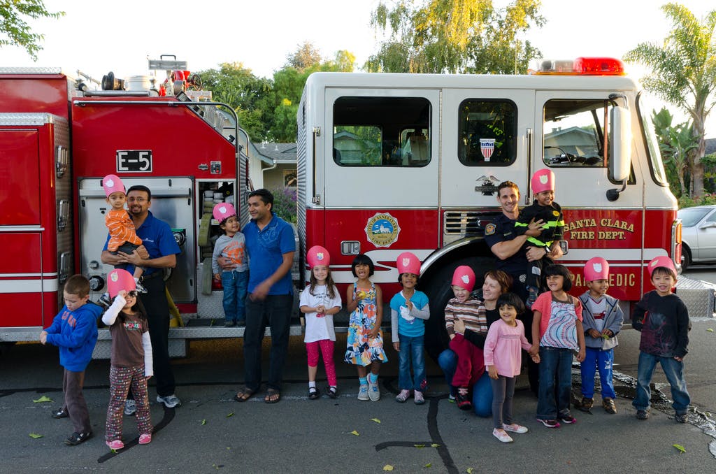 People and children posing with fire trucks