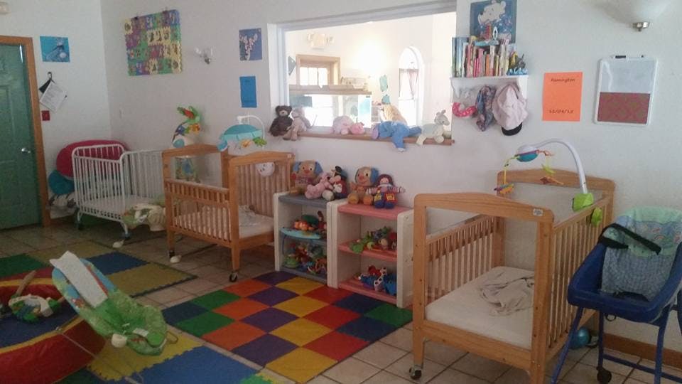 Room with multiple cribs and colorful play mats