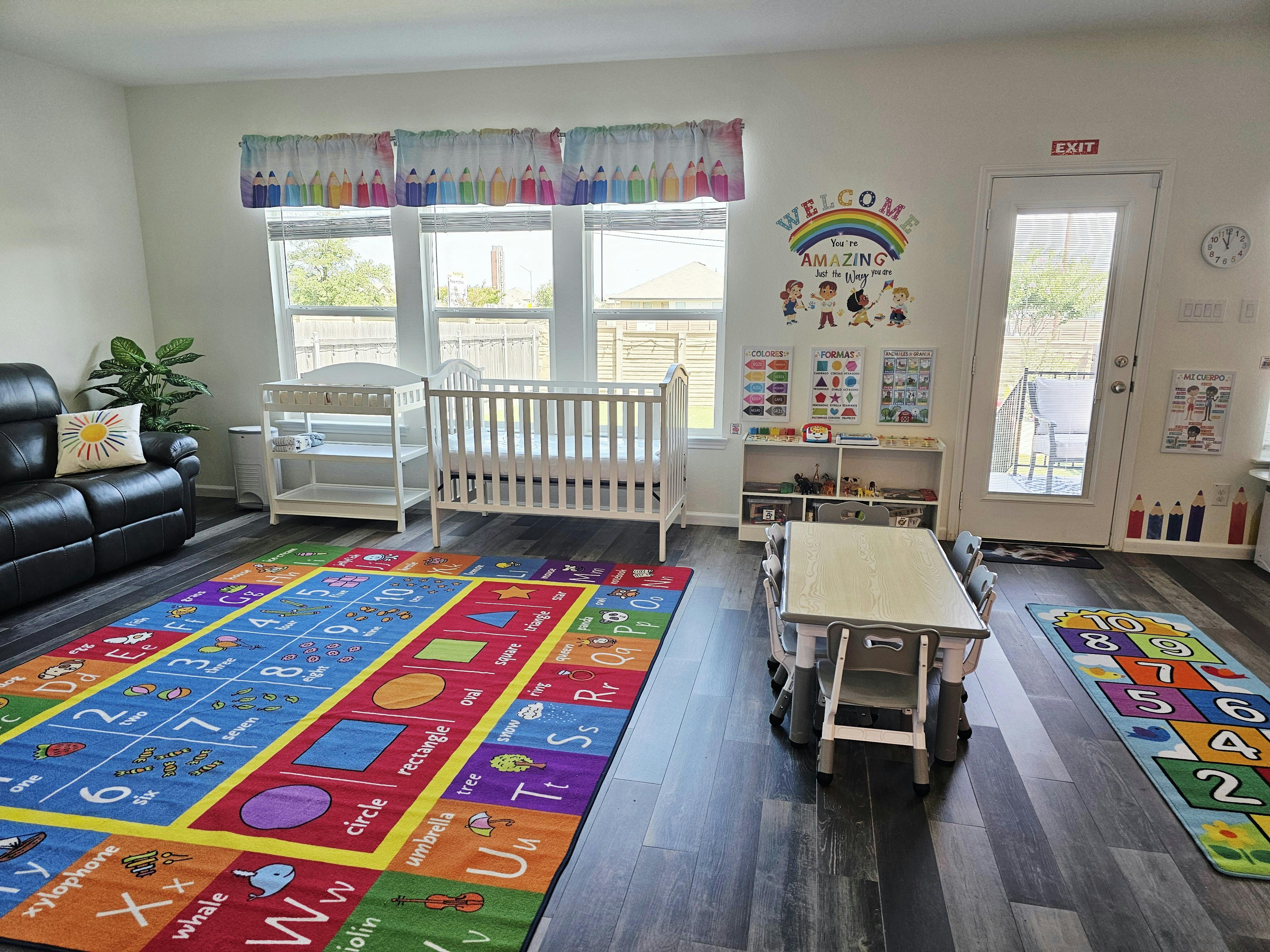 Child's room with crib, changing table, play rug, and small table with chairs