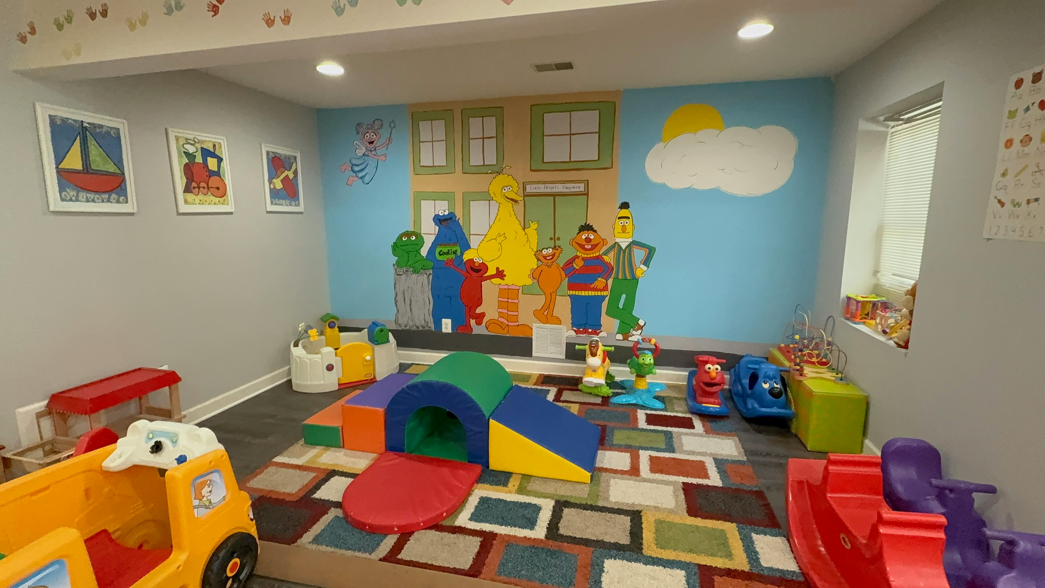 Playroom with a Sesame Street character mural and various children toys