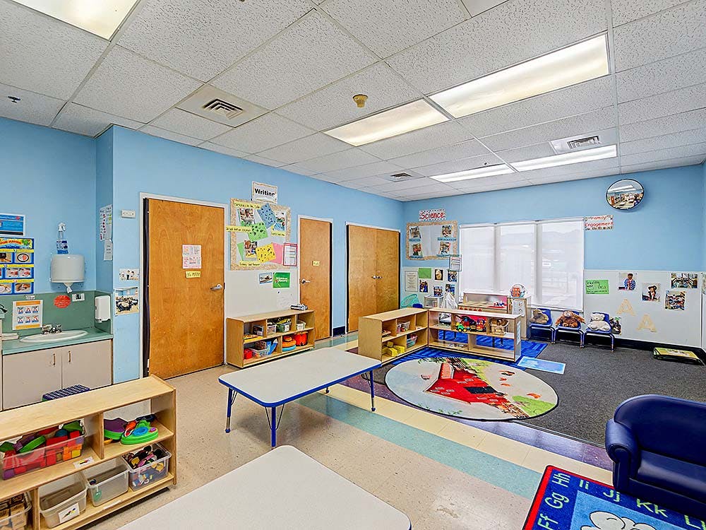 Empty colorful classroom with tables, chairs, and learning materials