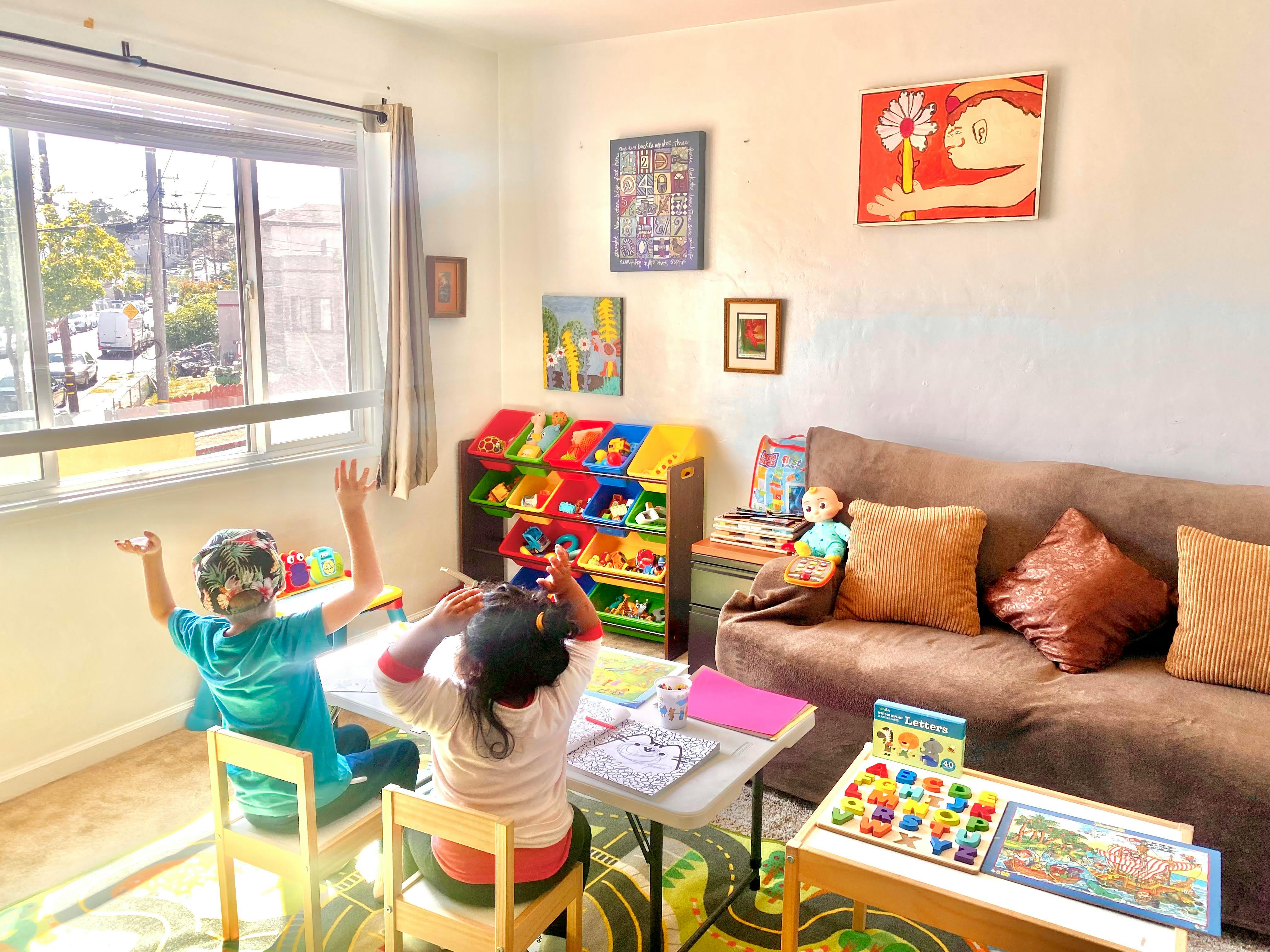 Two children sitting at a table with school supplies
