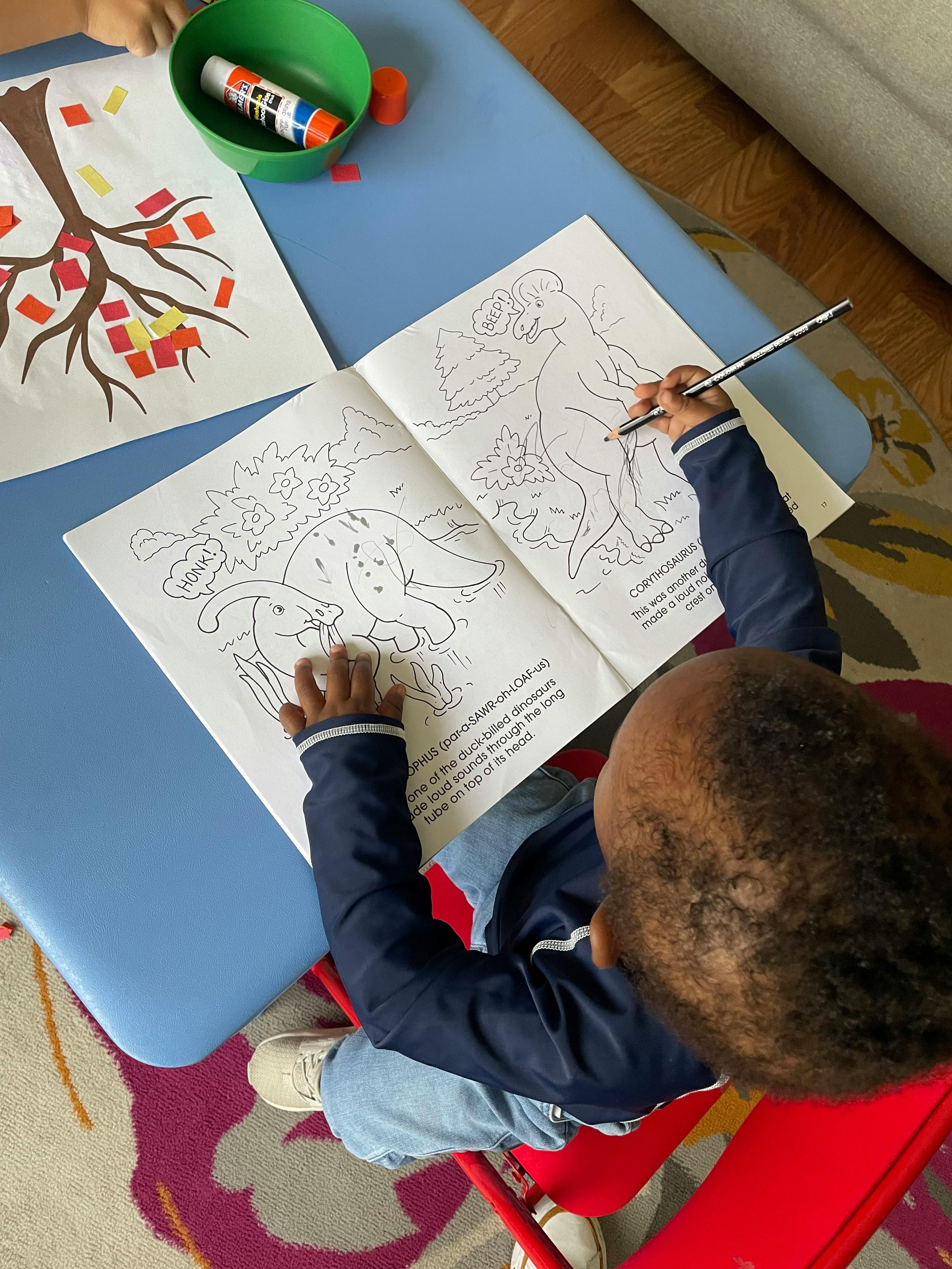 Child coloring in a book at a table