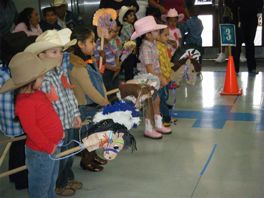 Children in cowboy hats with hobby horses