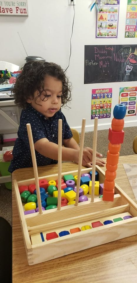 Child playing with a wooden shape sorter toy