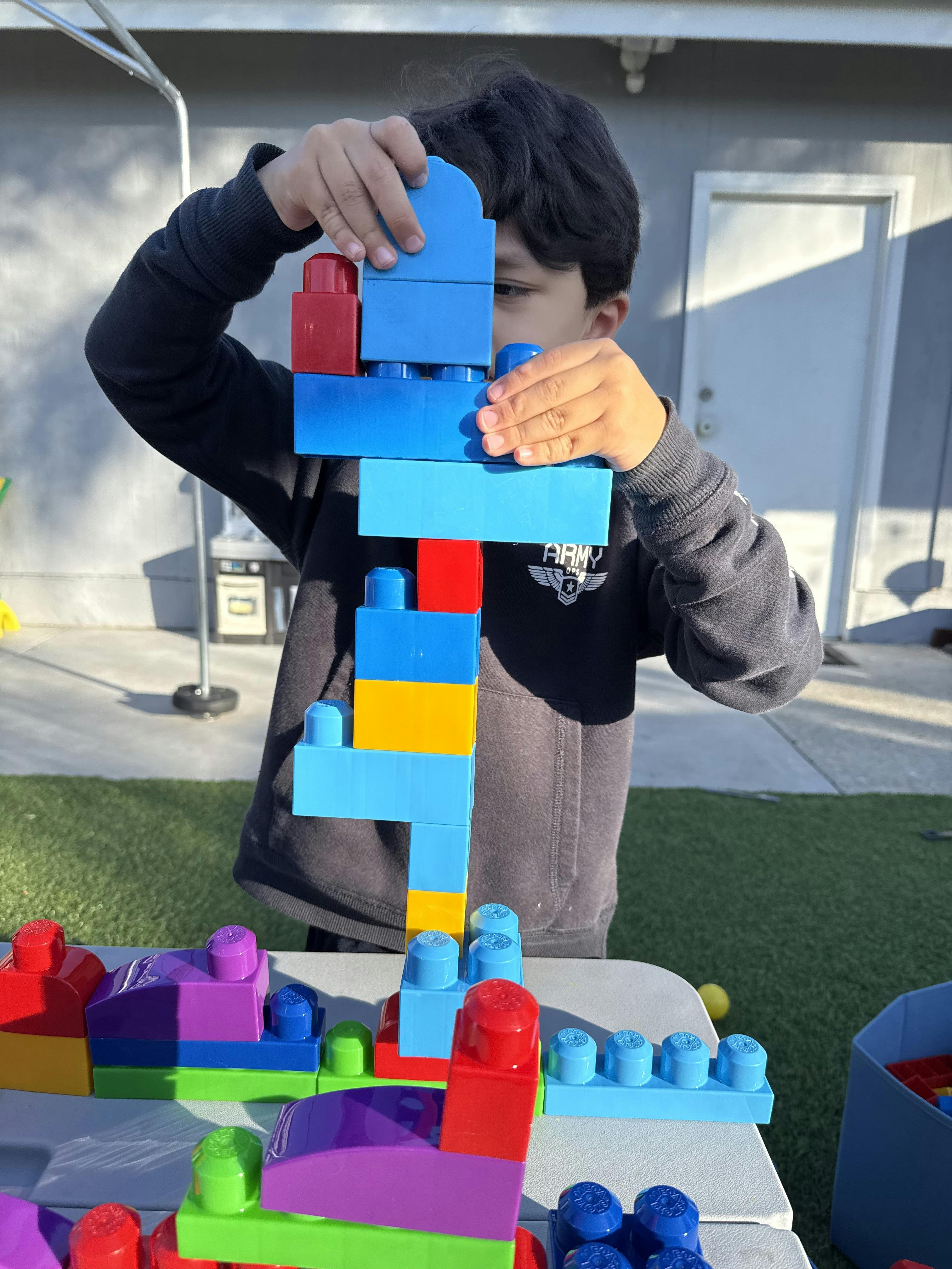 Child building a tower with large colorful blocks