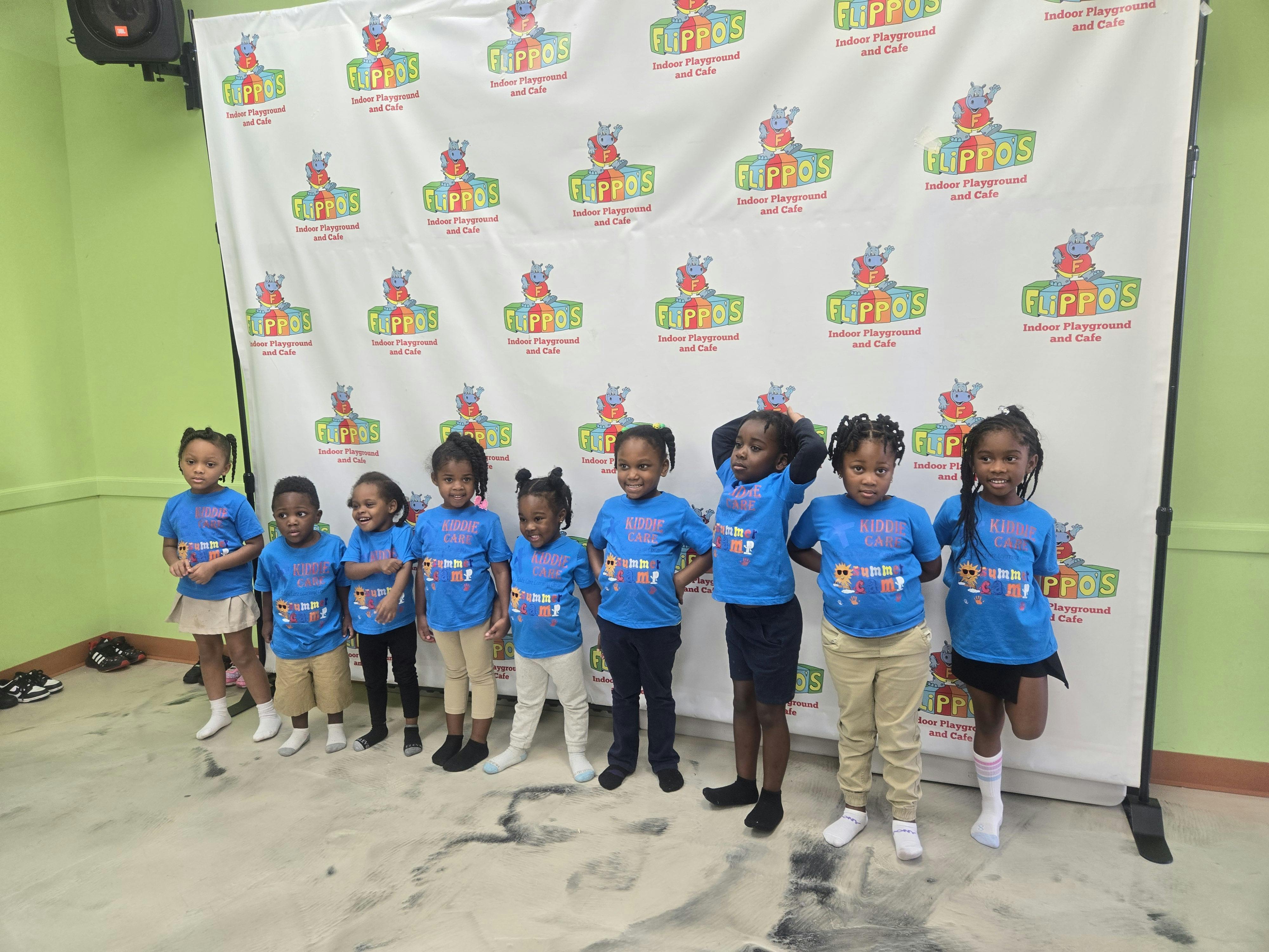 Group of children in blue shirts standing in a line
