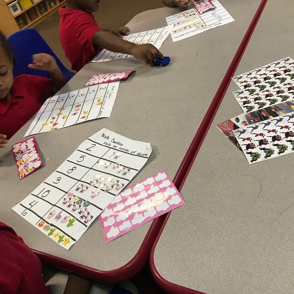Children at a table with papers and stickers