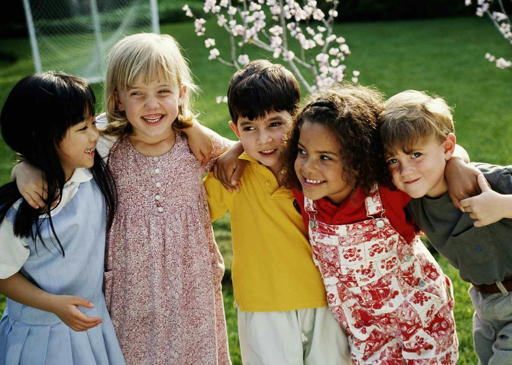 Five children with arms around each other outdoors