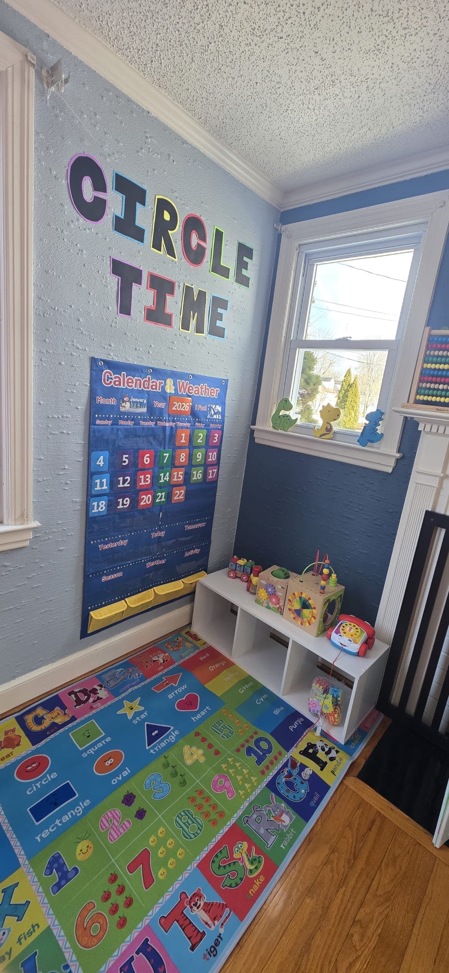 Classroom wall with "Circle Time" sign, calendar, and play mat on floor