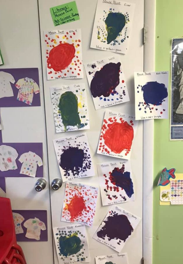 Children's artwork displayed on a door, featuring colorful paint splatters