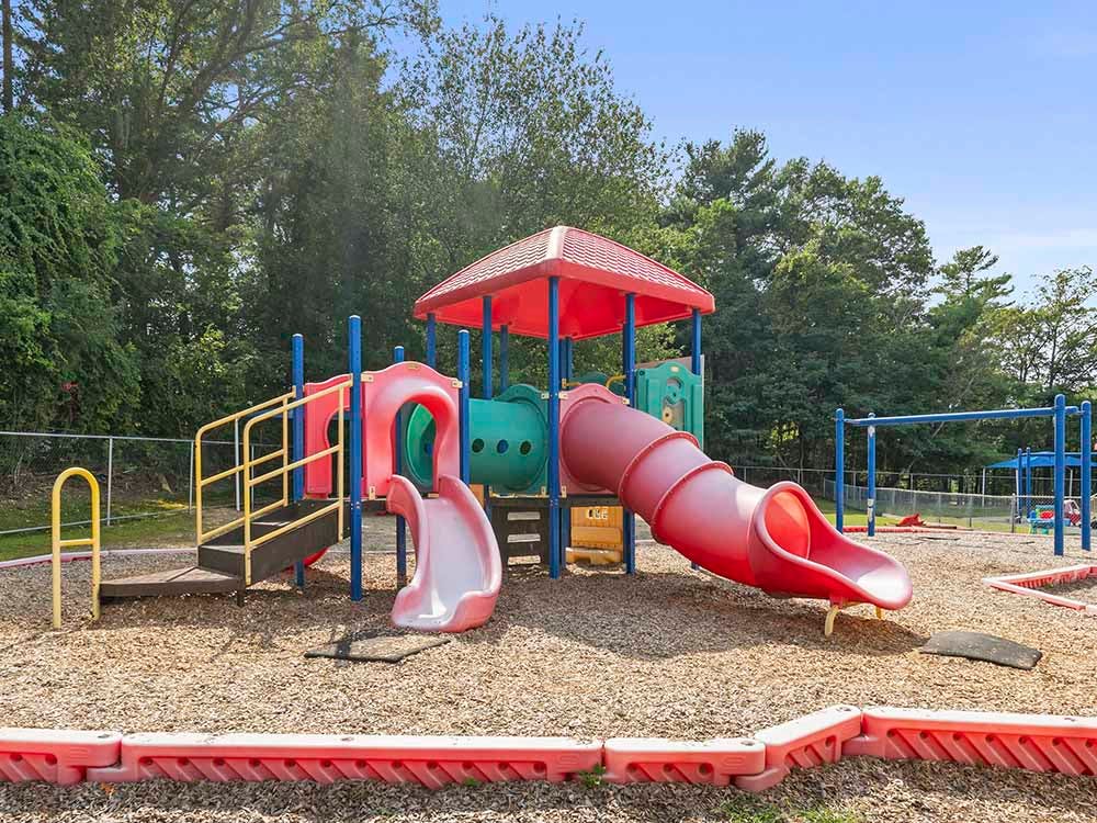 Colorful playground structure with slides and climbing areas on wood chips