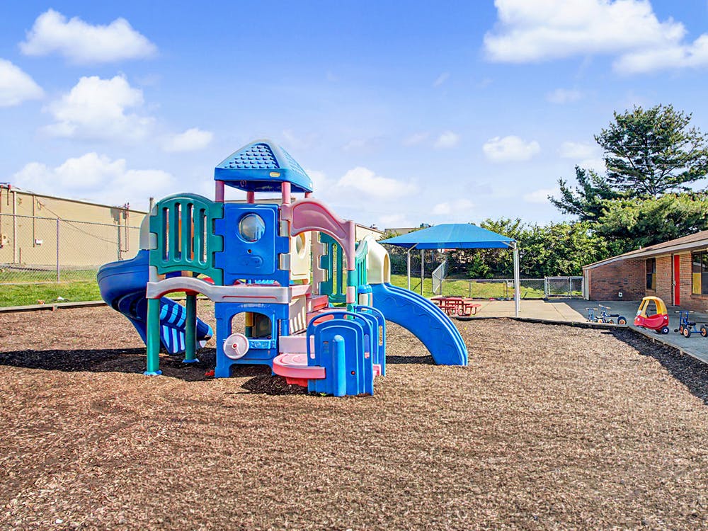 Colorful playground structure with slides on a wood chip ground