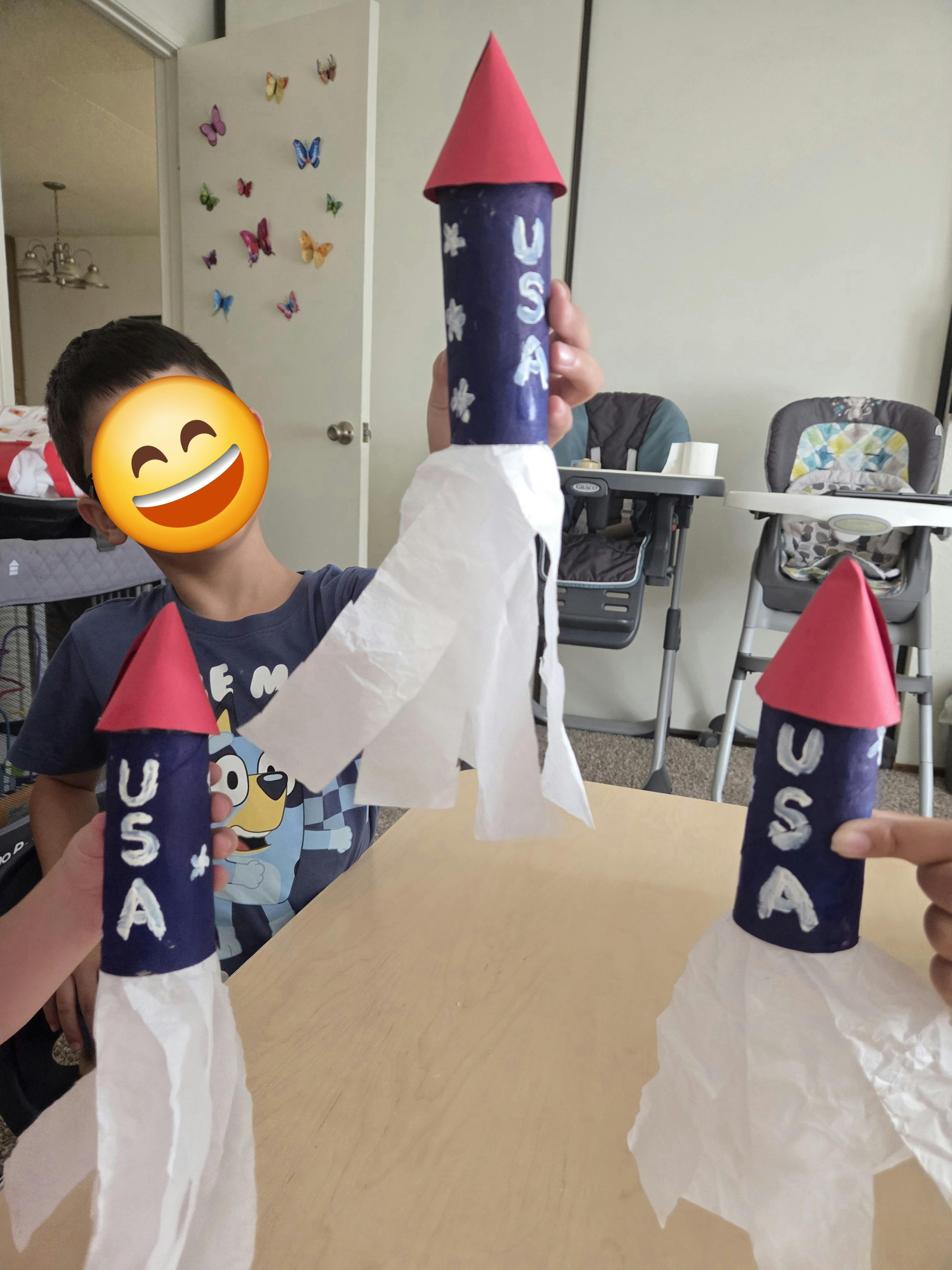 People holding handmade paper rockets with USA written on them