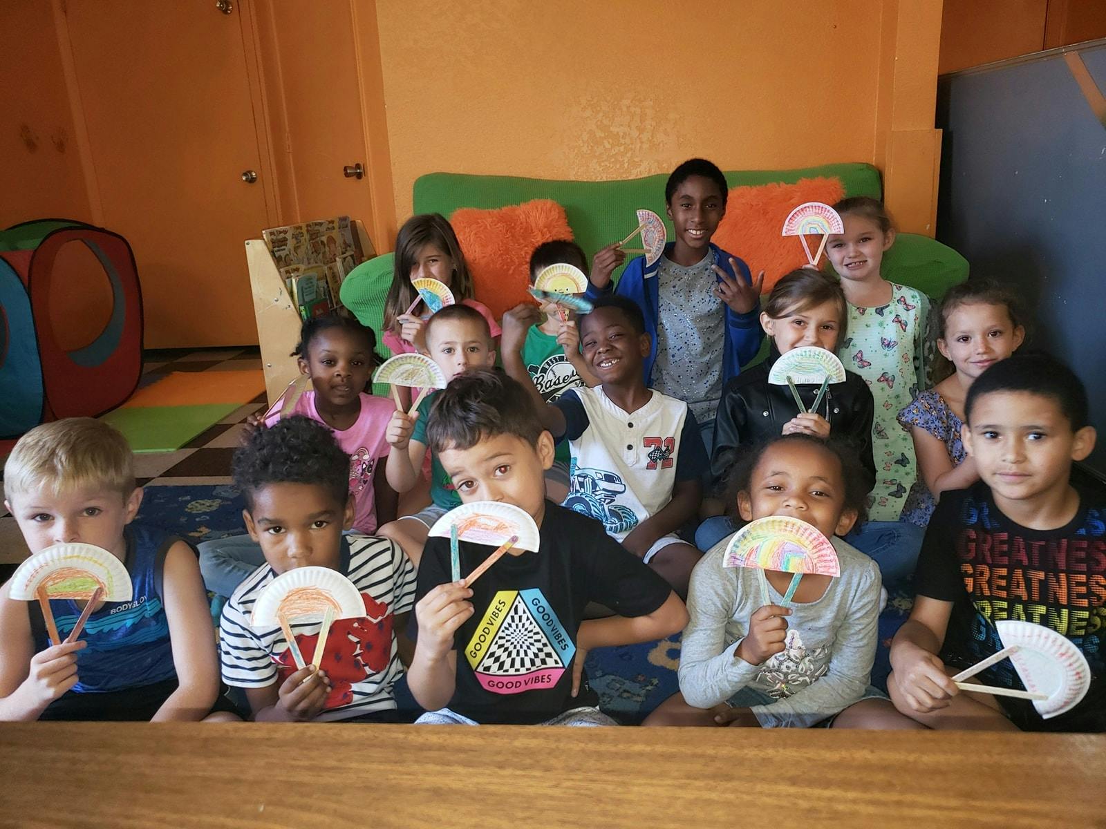 Group of children holding paper plate crafts