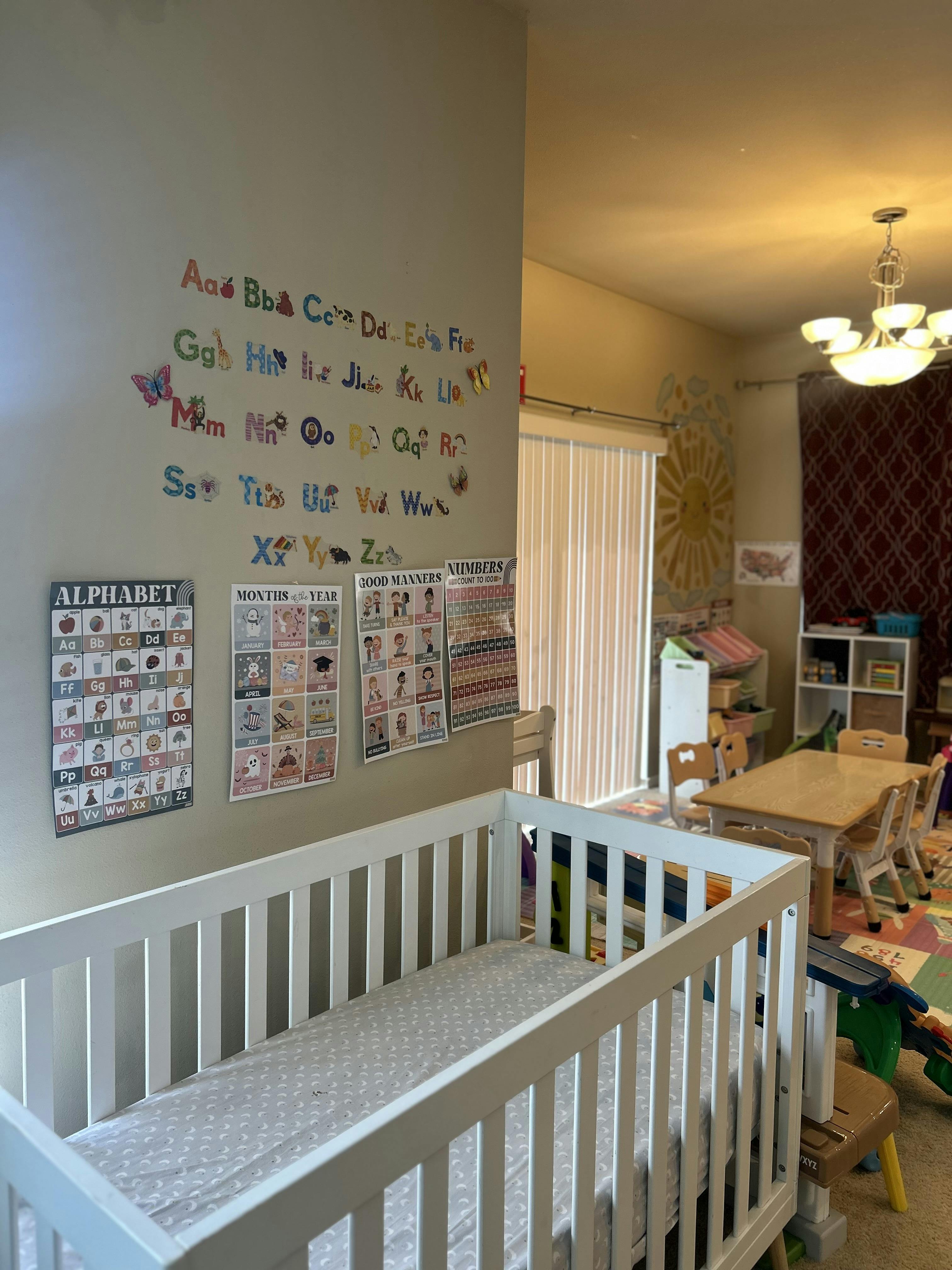 Crib in a room decorated with educational posters and child-sized furniture