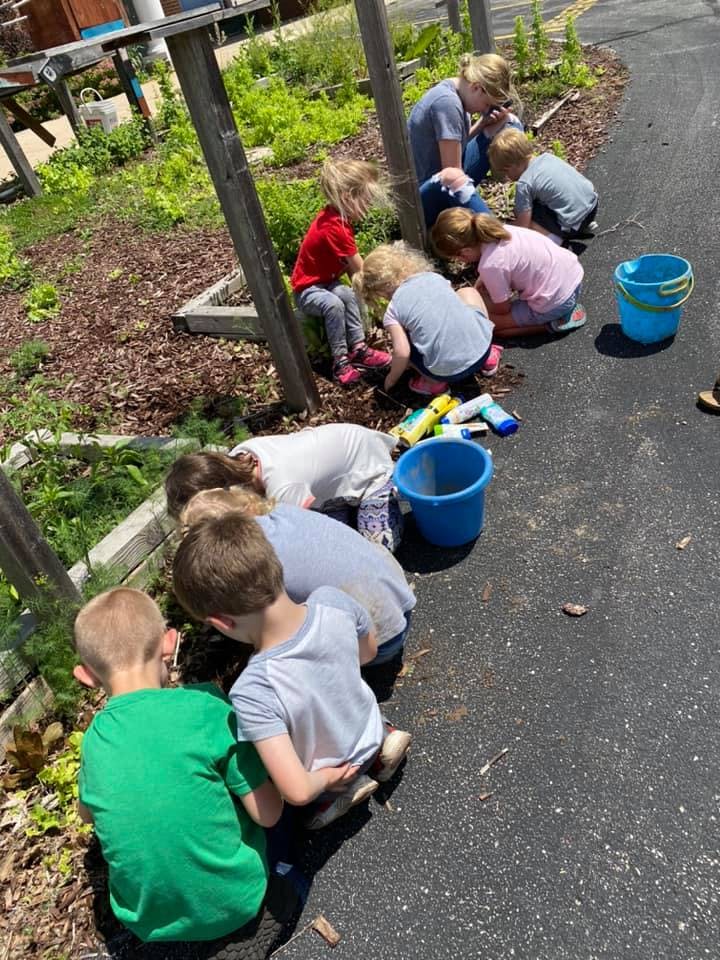 Children and adults gardening in a raised bed
