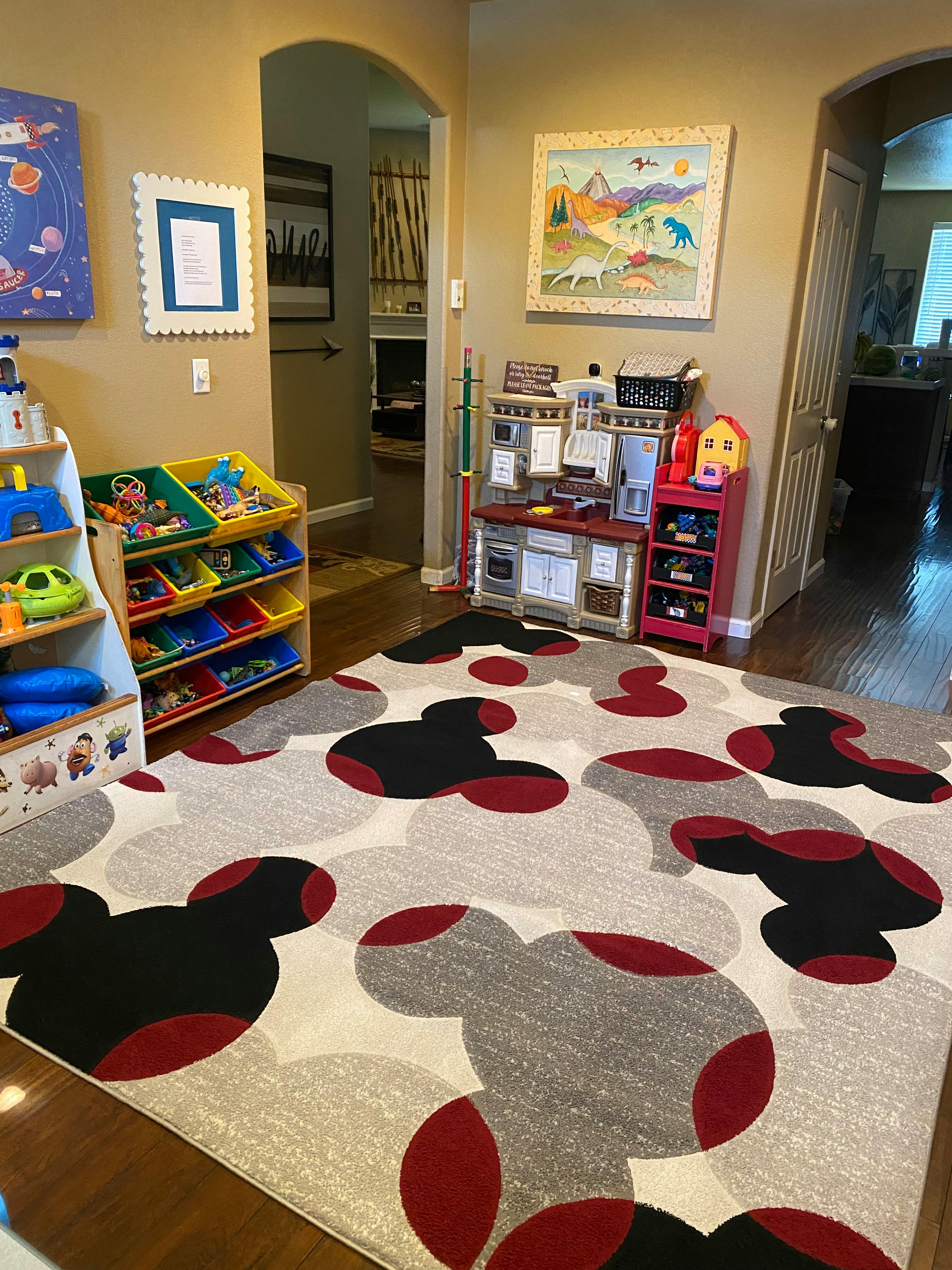 Playroom with toy shelves, play kitchen, and Mickey Mouse rug