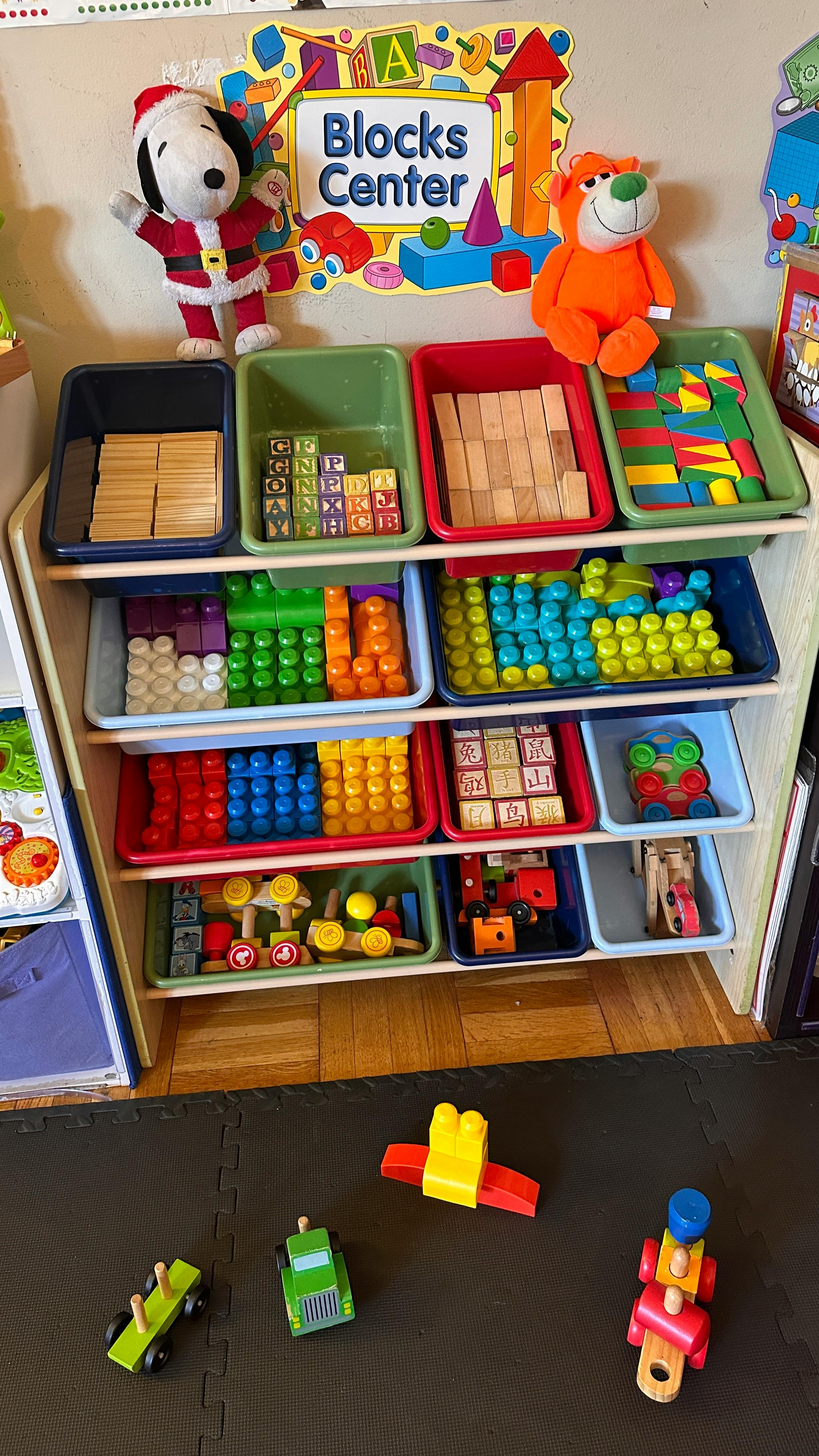 Shelves with bins of building blocks and toys, with a "Blocks Center" sign