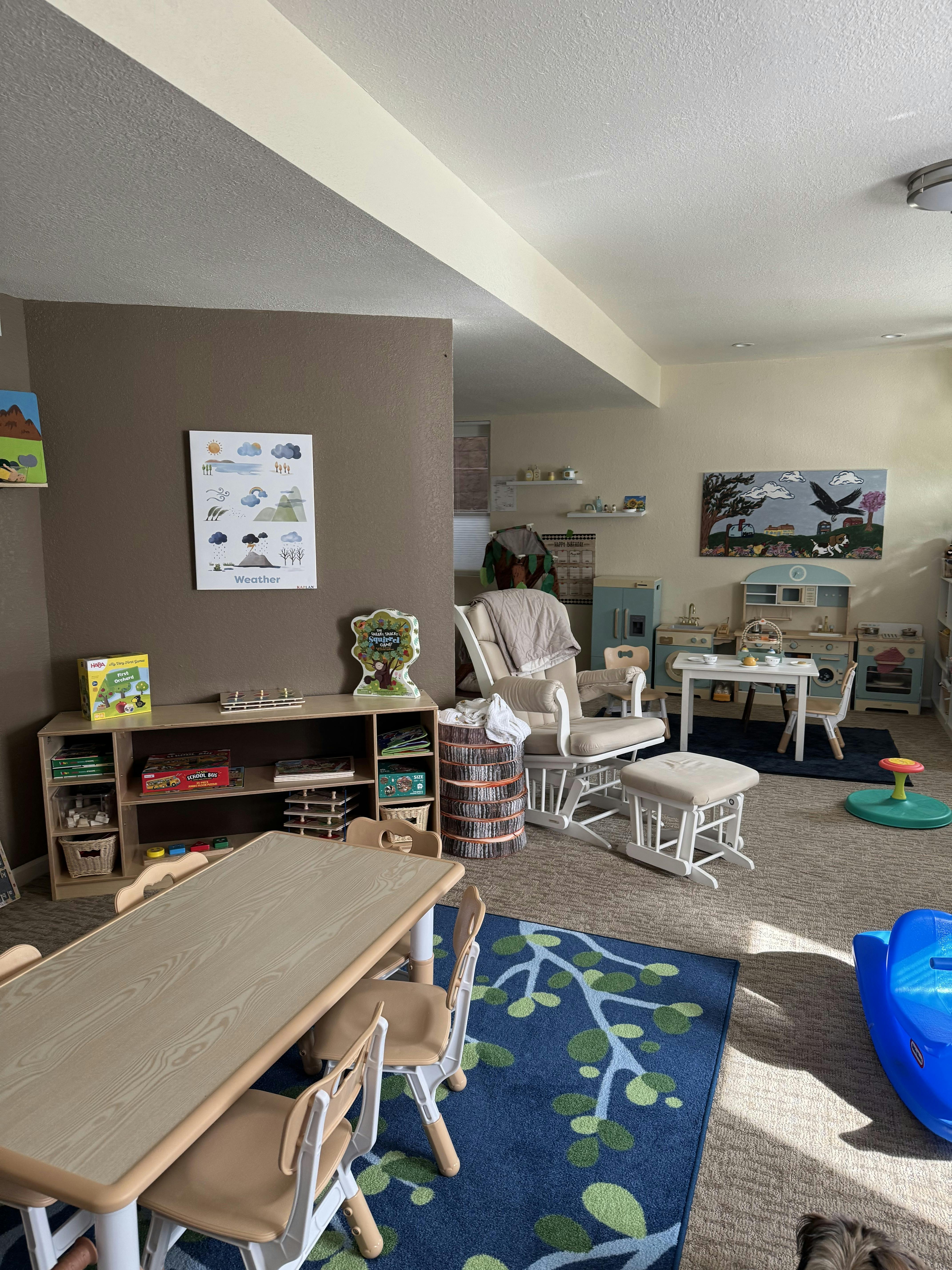 Playroom with small tables and chairs, a rocking chair, and storage shelves