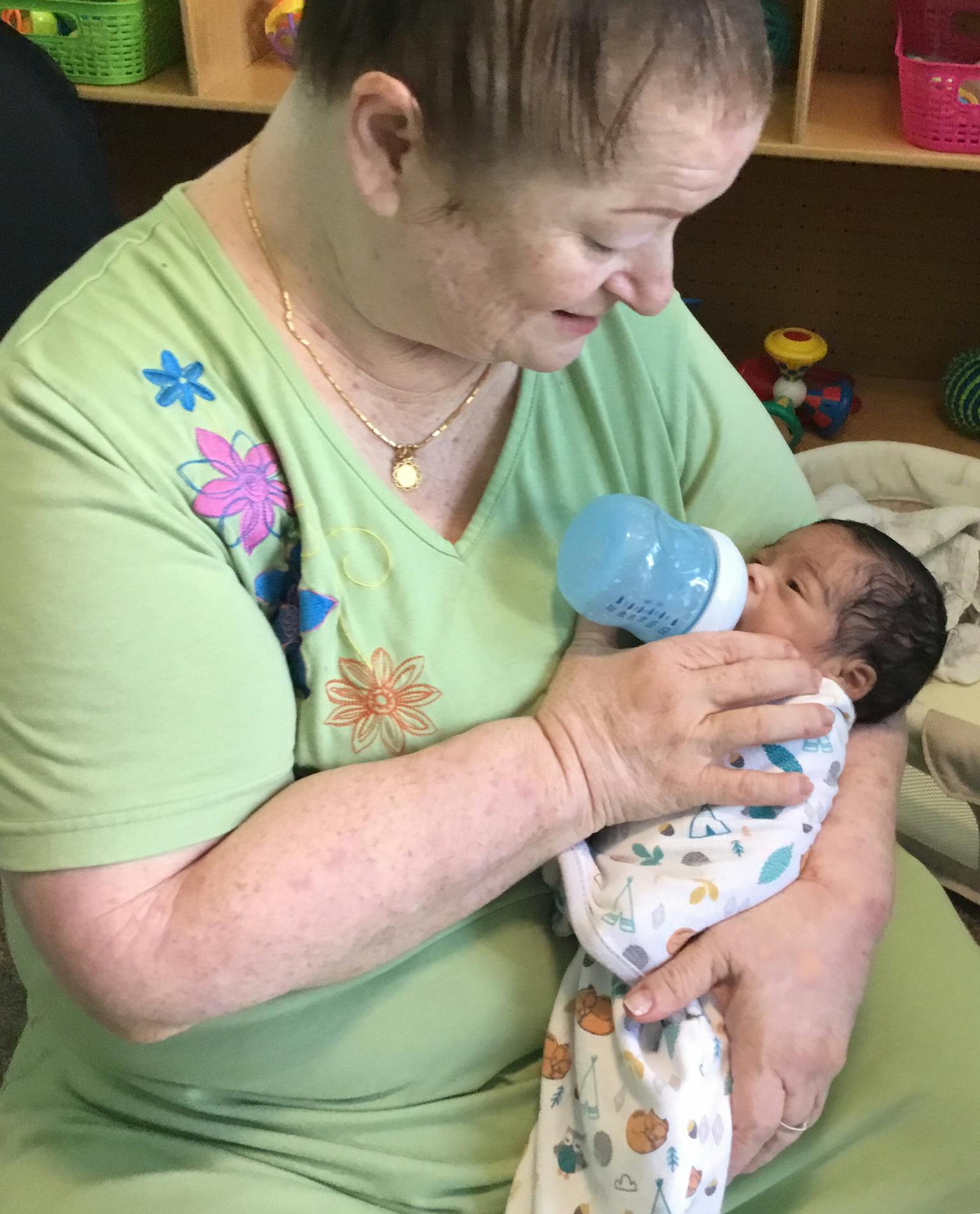 Person holding and bottle-feeding an infant