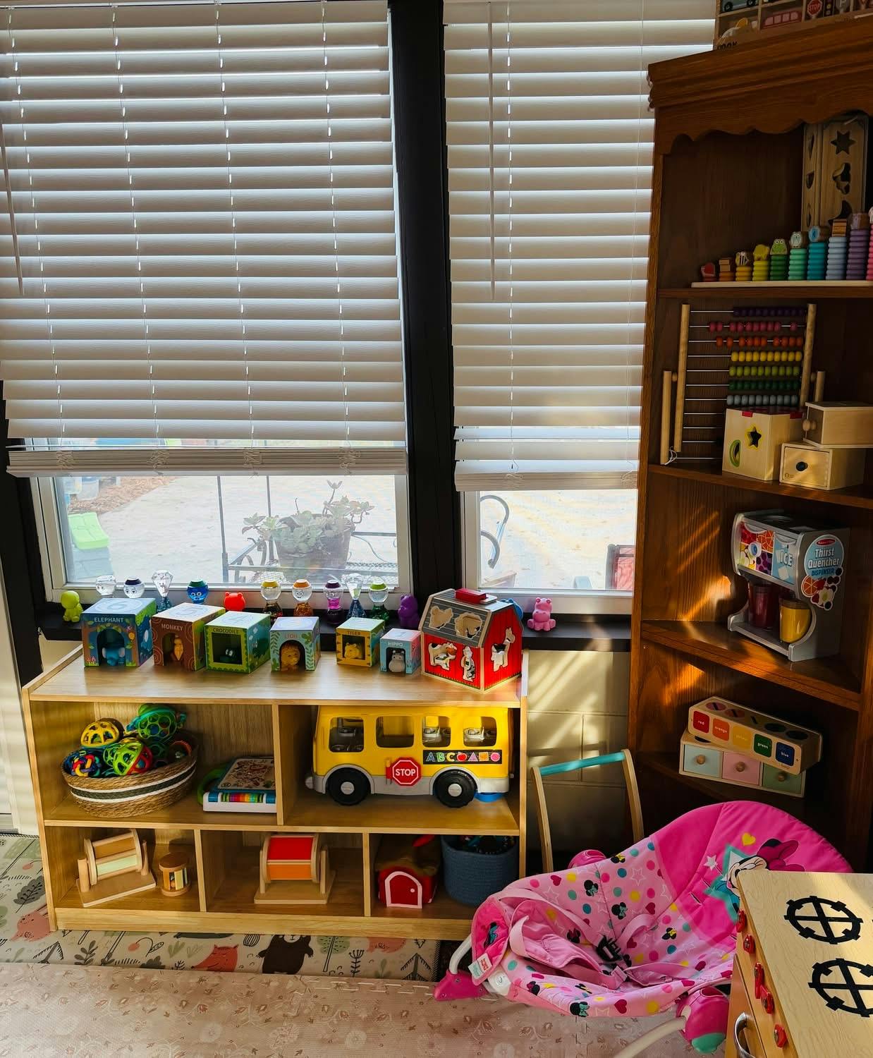 A playroom with wooden shelves holding colorful toys, blocks, and books