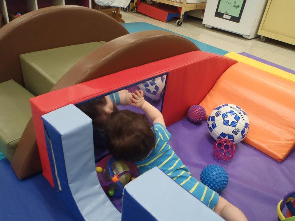 Child playing with soft blocks and a mirror