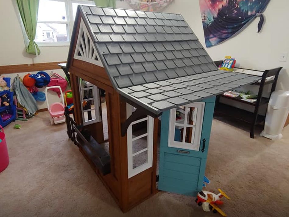 Toy playhouse with a gray roof and blue door