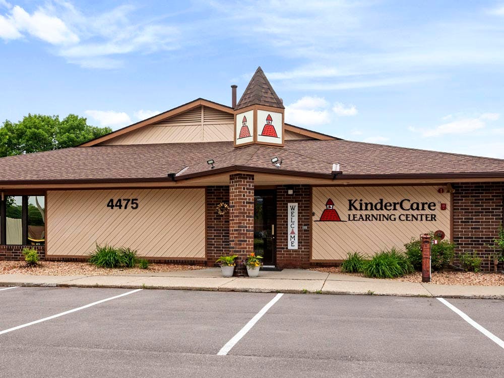 Exterior of a KinderCare Learning Center building with "WELCOME" sign