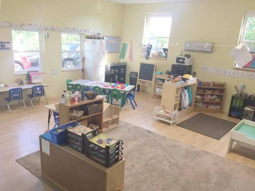 Classroom with tables, chairs, and shelves
