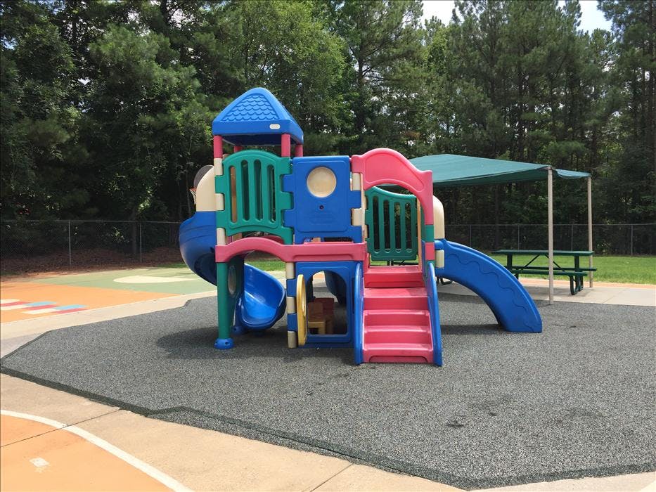 Colorful playground structure with slides and stairs on rubberized ground