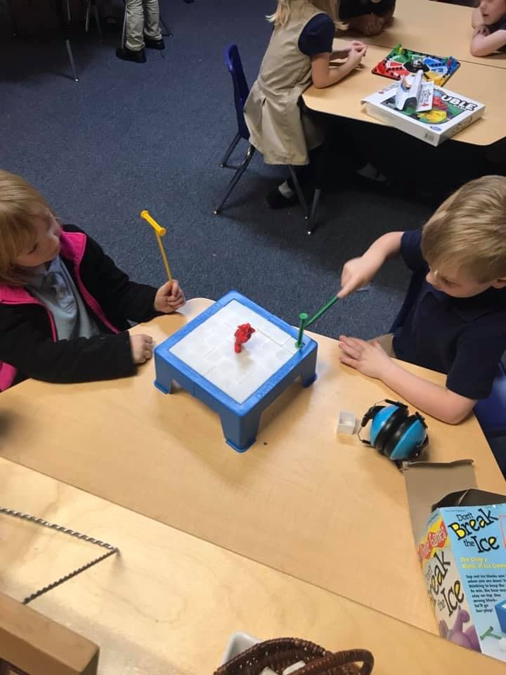 Two children playing a game at a table