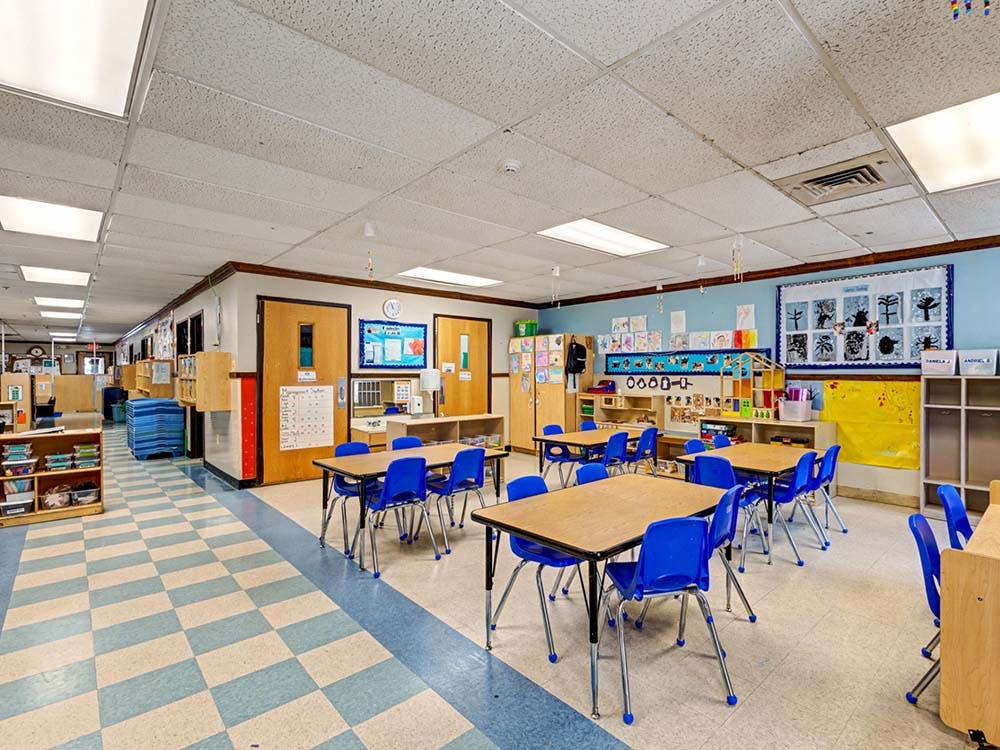 Empty classroom with small tables and blue chairs