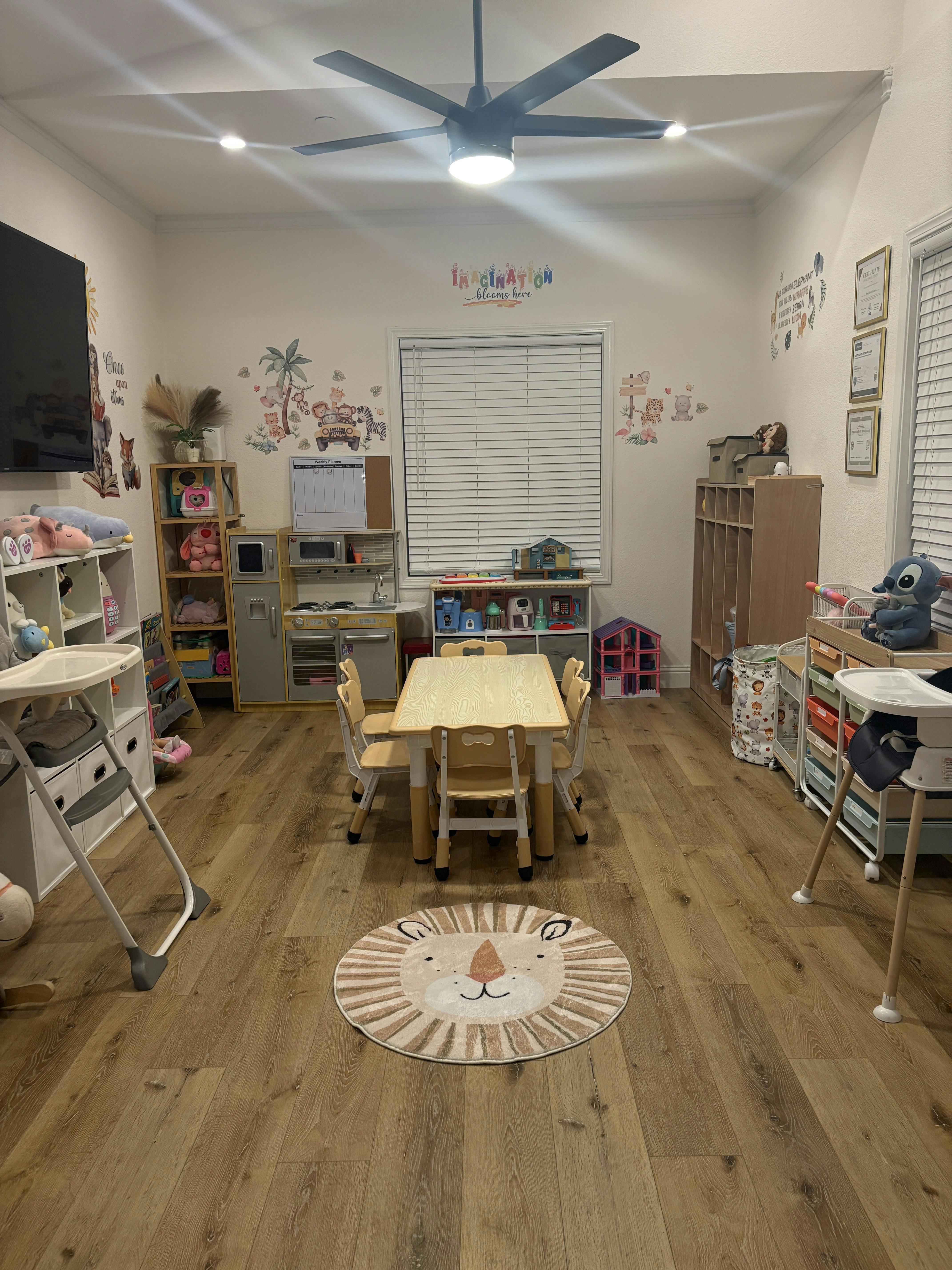 Playroom with small table and chairs, shelves with toys, and a lion rug