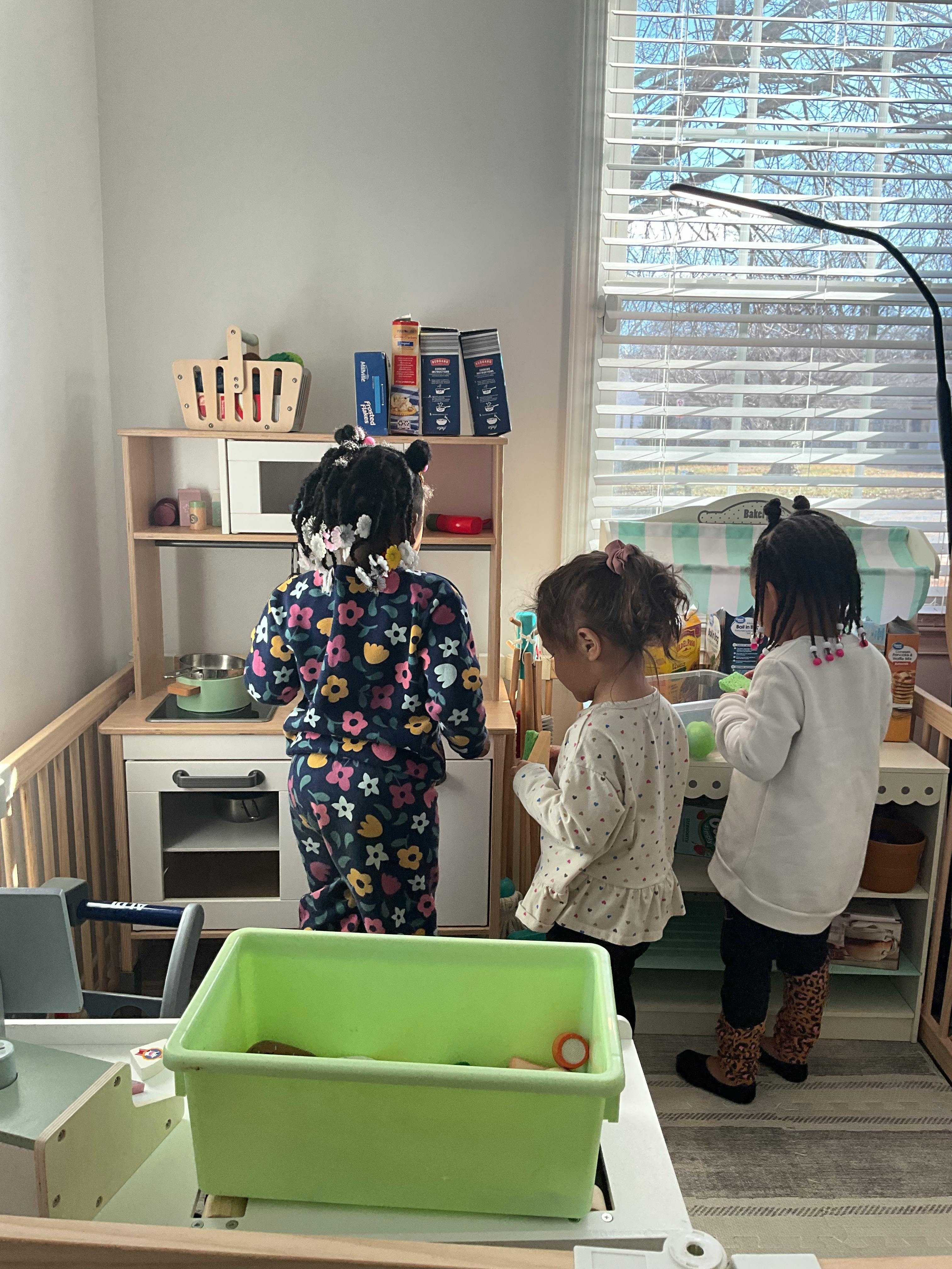 Two children playing with toy kitchen appliances