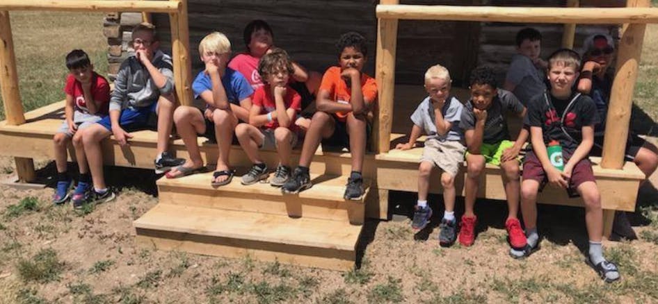 Group of children and teens sitting on wooden steps