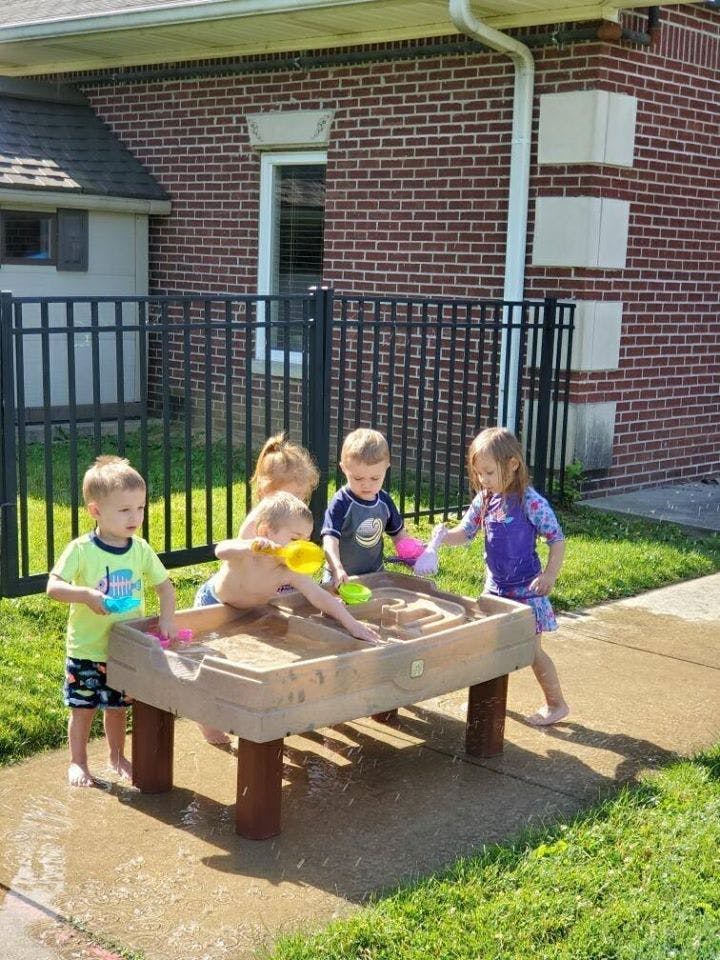 Children playing in a sand and water table outdoors