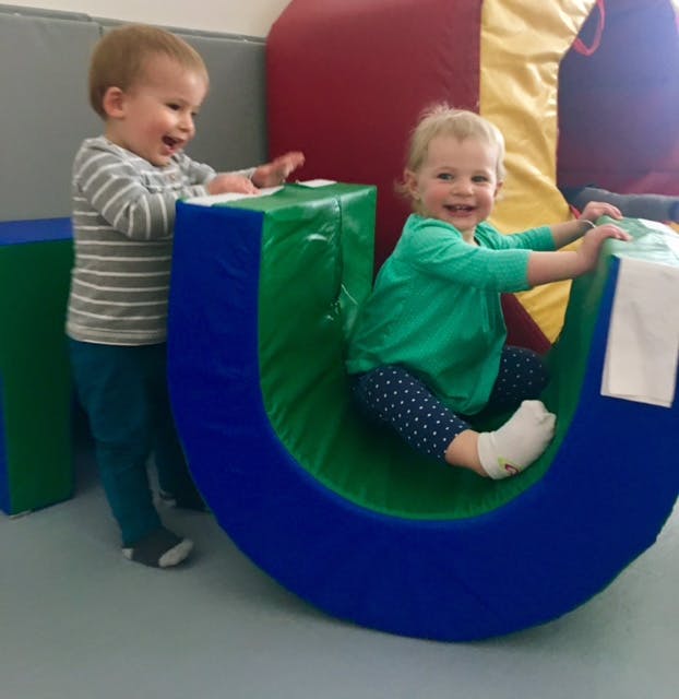 Two children playing with soft play equipment